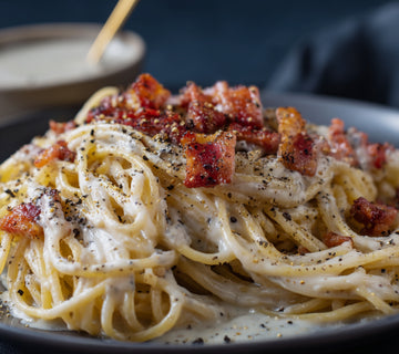 Creamy carbonara pasta topped with crispy bacon and SwissAm Pepper Mélange